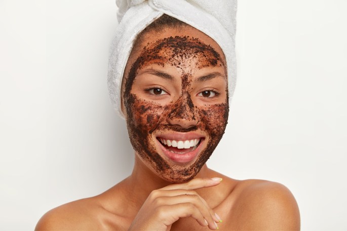 Beautiful girl with coffee face mask and beautiful smile